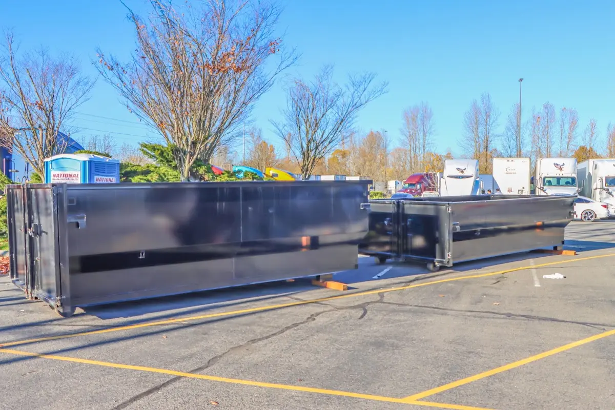 Professional dumpster rental service with roll-off container on residential driveway in Fishhook
